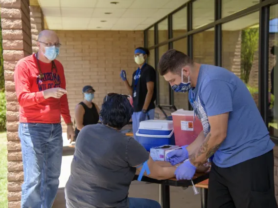 Man collecting blood sample outside during the COVID-19 pandemic