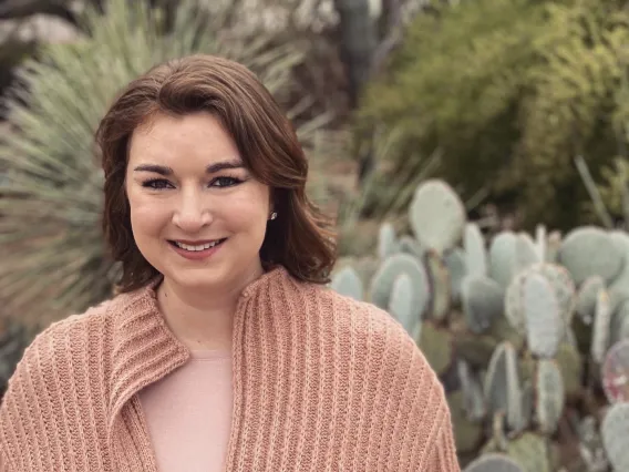 Elizabeth Wright smiling for photo in front of cactus garden