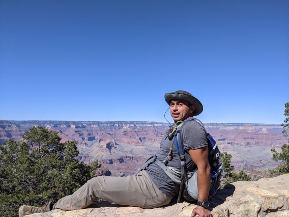 Cesar Medina posing for photo on edge of Grand Canyon