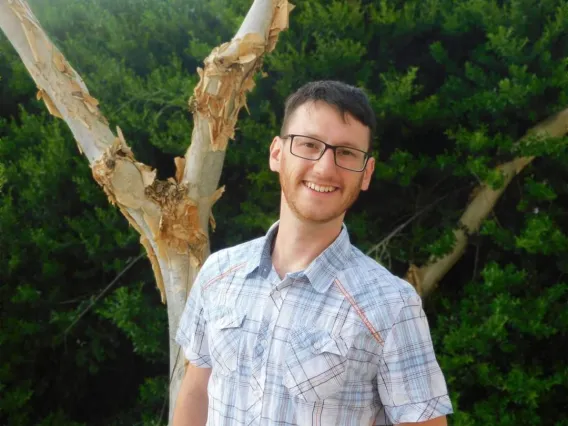 Brady Hasse posing for photo under tree