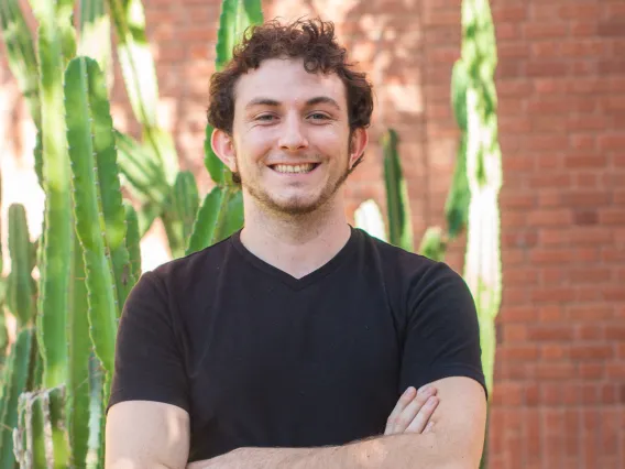 Matthew Schmit smiling for photo with arms crossed