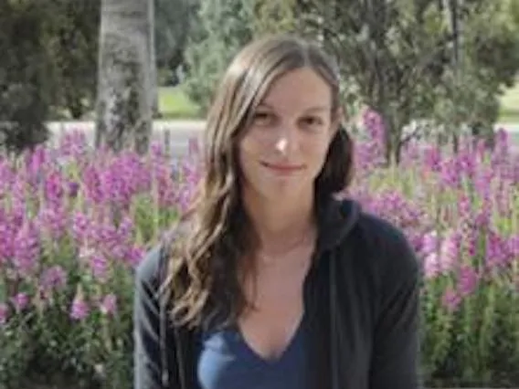Meaghan Torvund smiling for photo in front of flowers