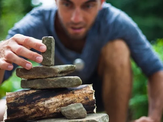 Person stacking rocks on top of each other carefully