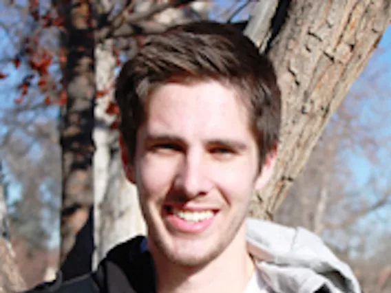 Clayton Mosher smiling for photo in front of tree