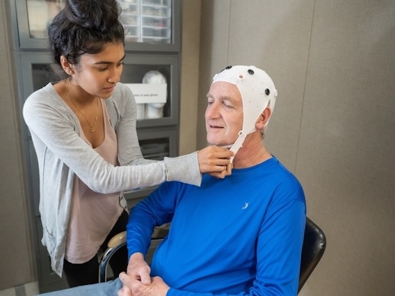 Elderly individual wearing a brain cap and participating in a test
