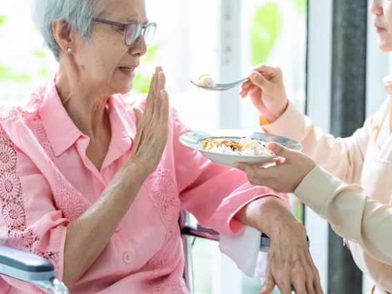 Elderly woman refusing to eat food she's being offered