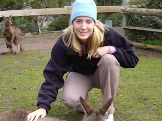 Penny Dacks (Letts) smiling for photo while petting a kangaroo
