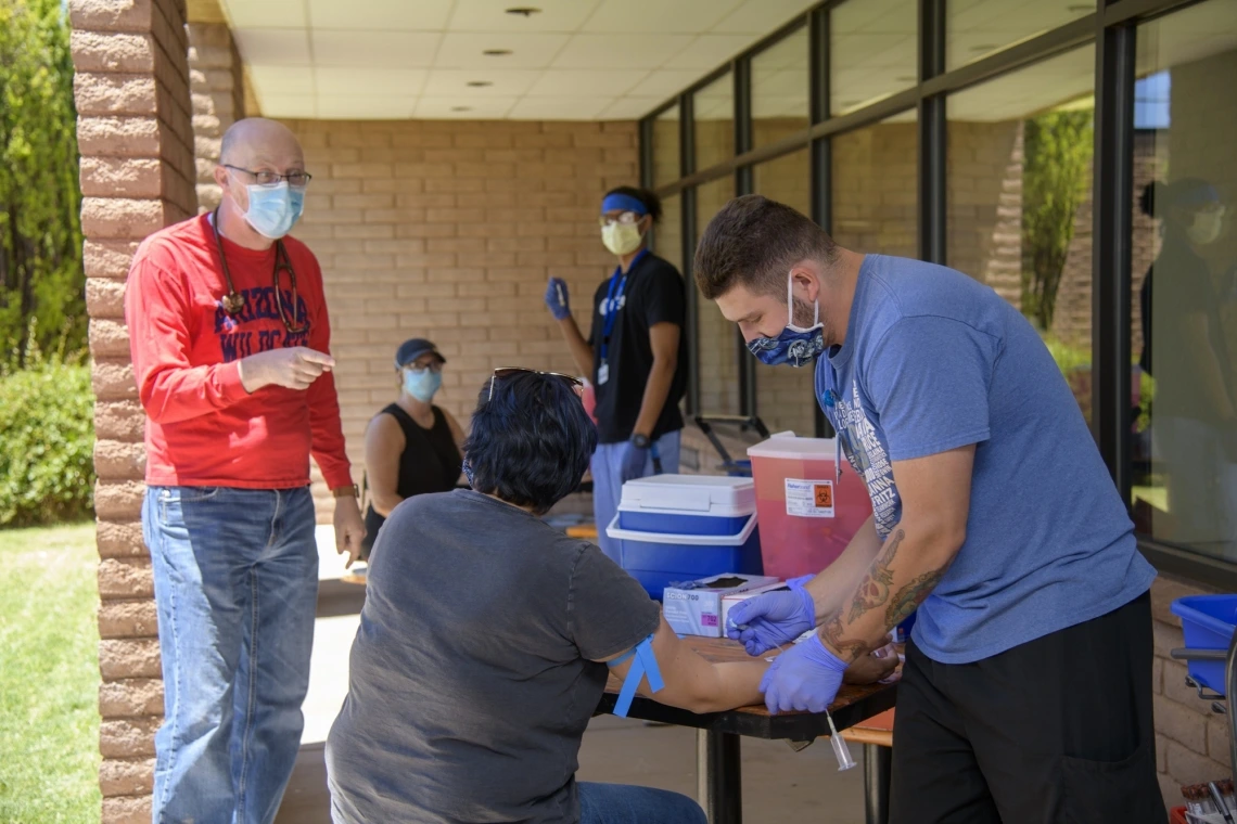 Man collecting blood sample outside during the COVID-19 pandemic