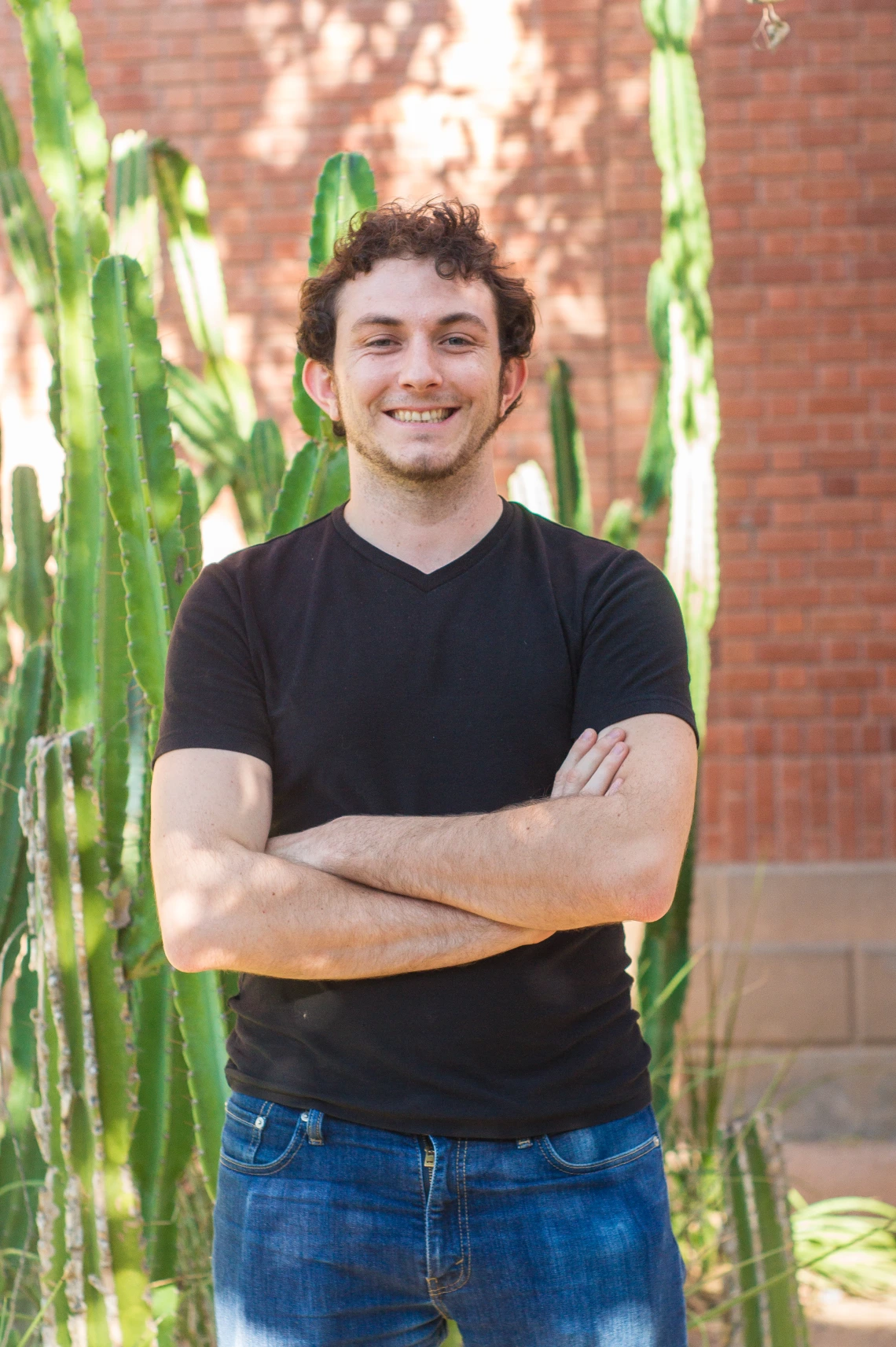 Matthew Schmit smiling for photo with arms crossed