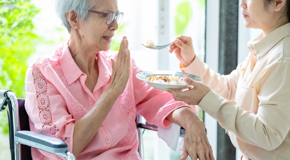 Elderly woman refusing to eat food she's being offered