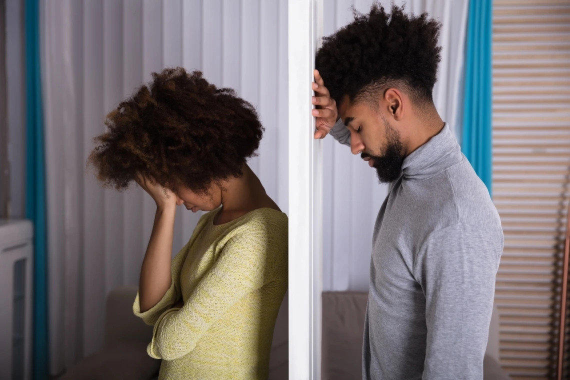 Distressed couple separated by a wall