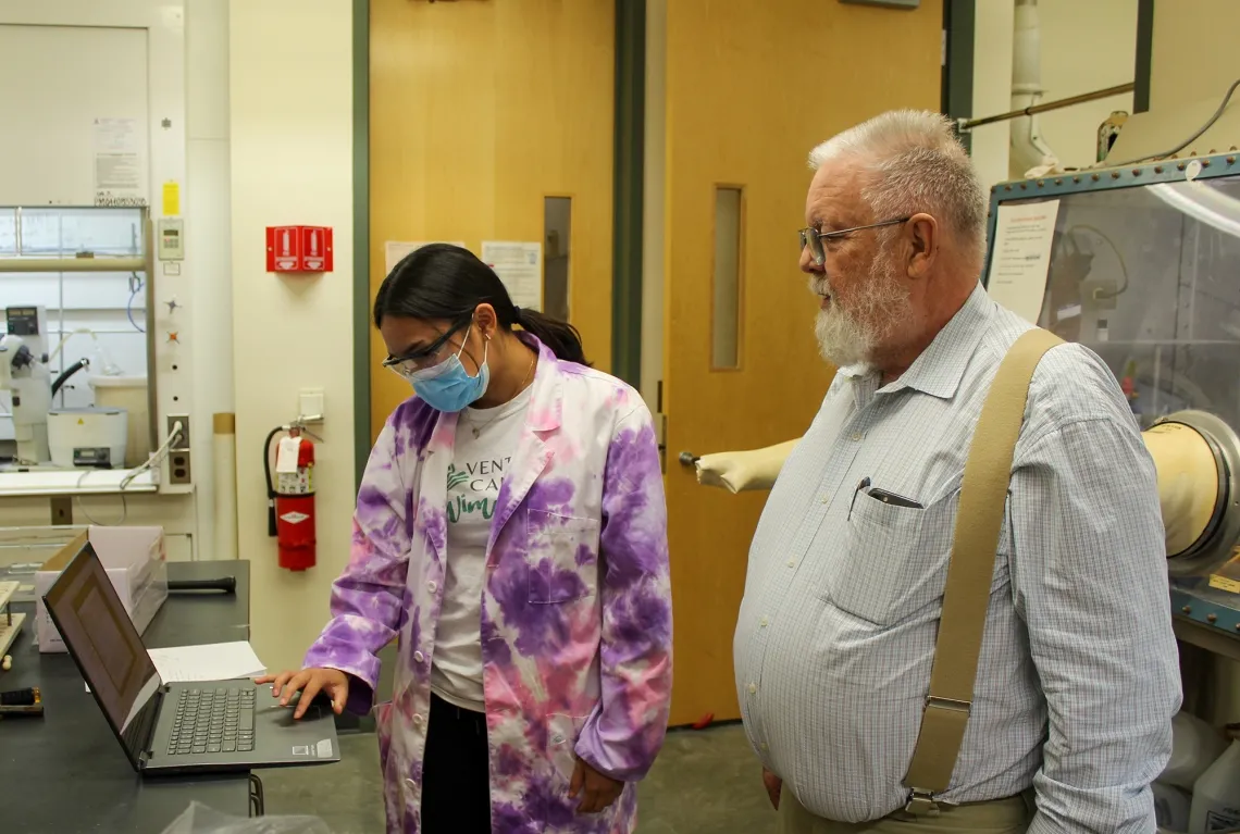 Two scientists working on a computer in a lab