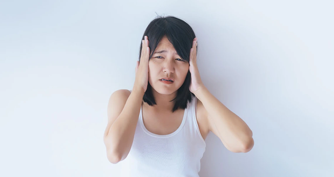 Person holding head in hands from pain