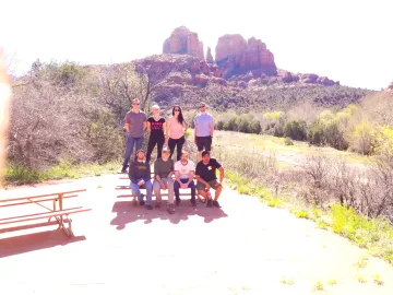 Group of students posing for group photo on a picnic bench